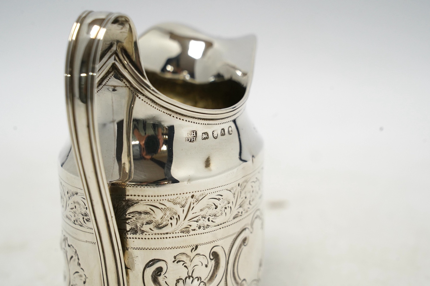 A George III silver cream jug, with later decoration, Robert & David Hennell, London, 1796, 10.4cm, 3.5oz. Condition - poor to fair